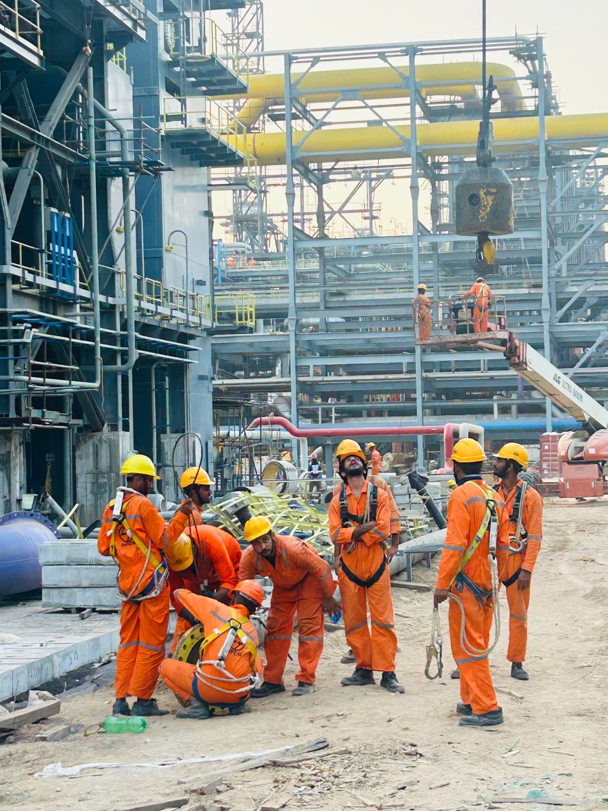 Construction workers in safety gear at an industrial worksite